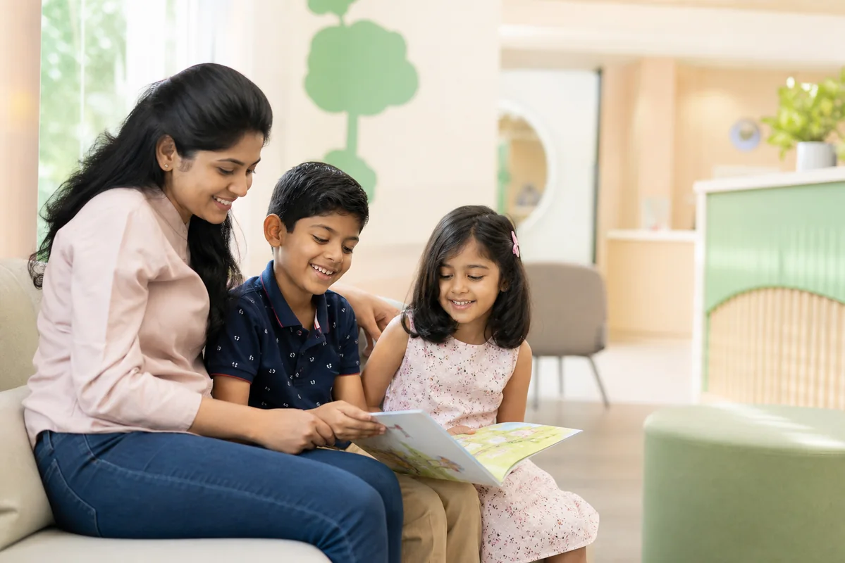 Two children reading with their mother in a welcoming pediatric clinic